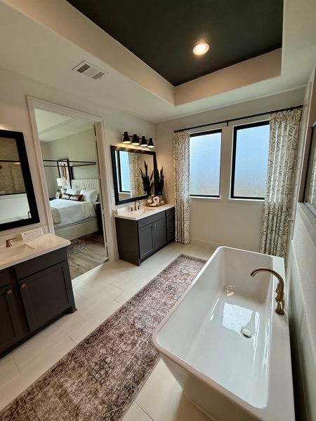 Elegant bathroom with a freestanding tub, dual vanities, and modern fixtures, exuding a sleek and sophisticated vibe.