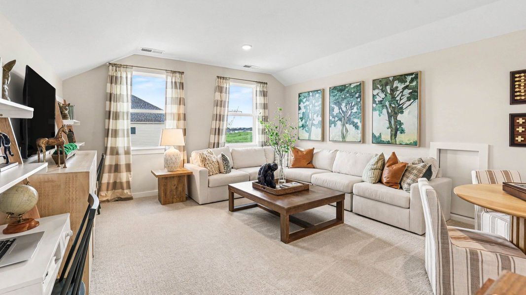 Spacious loft area with carpet and windows Spacious loft area with carpet and windows