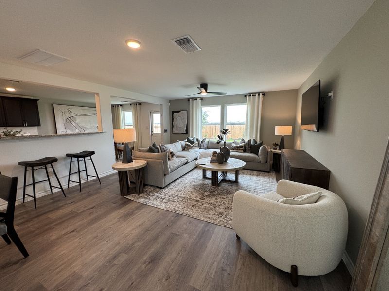A cozy living room with a spacious sectional, modern art, and stylish floor lamps, featuring a warm and inviting ambiance.