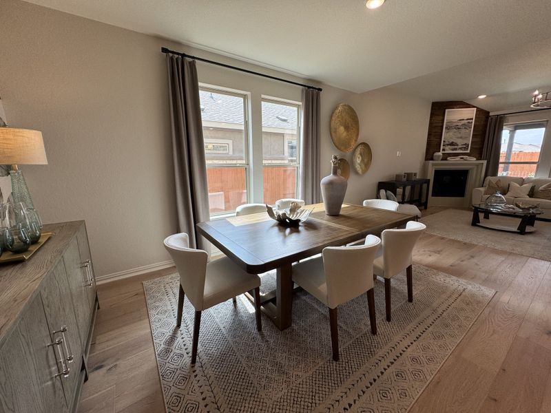 A cozy dining area features a wooden table, cream chairs, and modern decor, seamlessly flowing into a stylish living room. A cozy dining area features a wooden table, cream chairs, and modern decor, seamlessly flowing into a stylish living room.