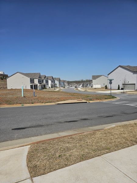A charming street view in Braselton Village by D.R. Horton, showcasing neat homes under a clear blue sky in Braselton, GA.