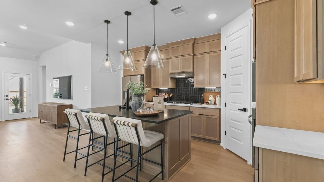 River Ranch home showcases sleek pendant lighting, elegant wood cabinetry, and a chic black island. River Ranch home showcases sleek pendant lighting, elegant wood cabinetry, and a chic black island.