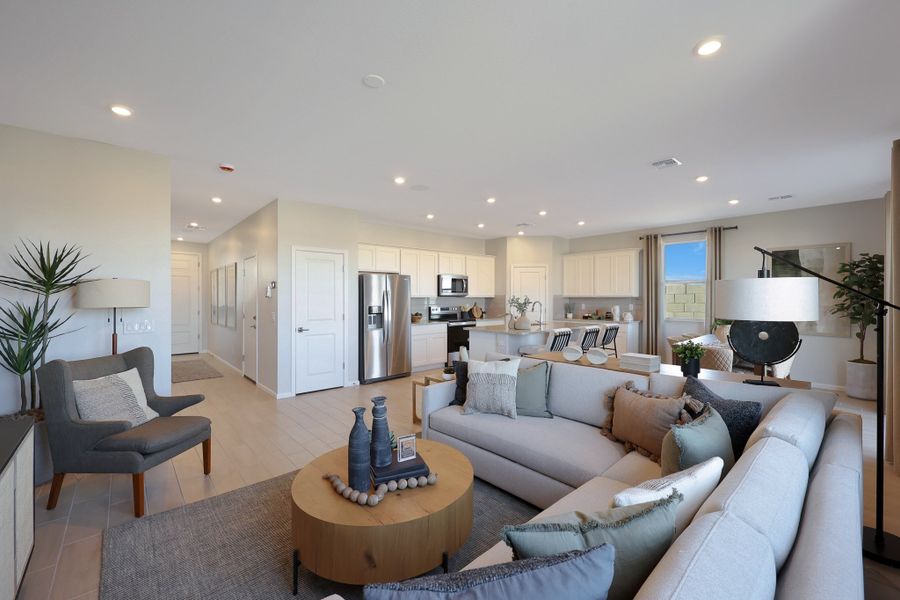 A living room with a large couch and a dining table. A living room with a large couch and a dining table.