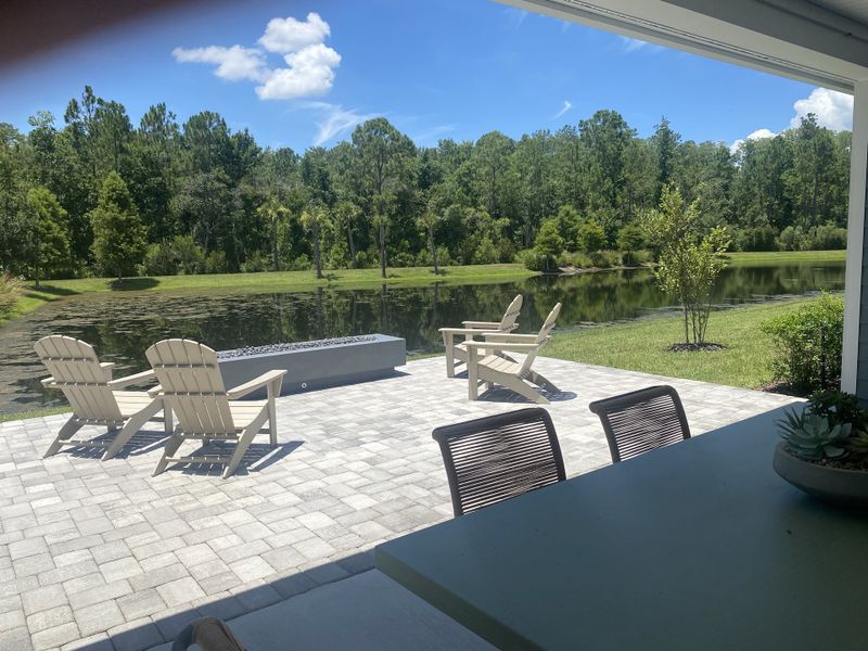 A serene patio overlooking a pond with Adirondack chairs, surrounded by lush greenery. Perfect for tranquil outdoor relaxation. A serene patio overlooking a pond with Adirondack chairs, surrounded by lush greenery. Perfect for tranquil outdoor relaxation.