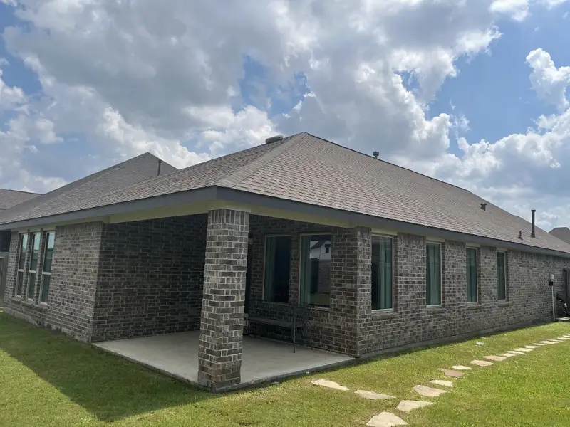 A charming brick home with a covered patio in Jordan Ranch: Pinnacle Collection by Lennar (Fulshear, TX).
