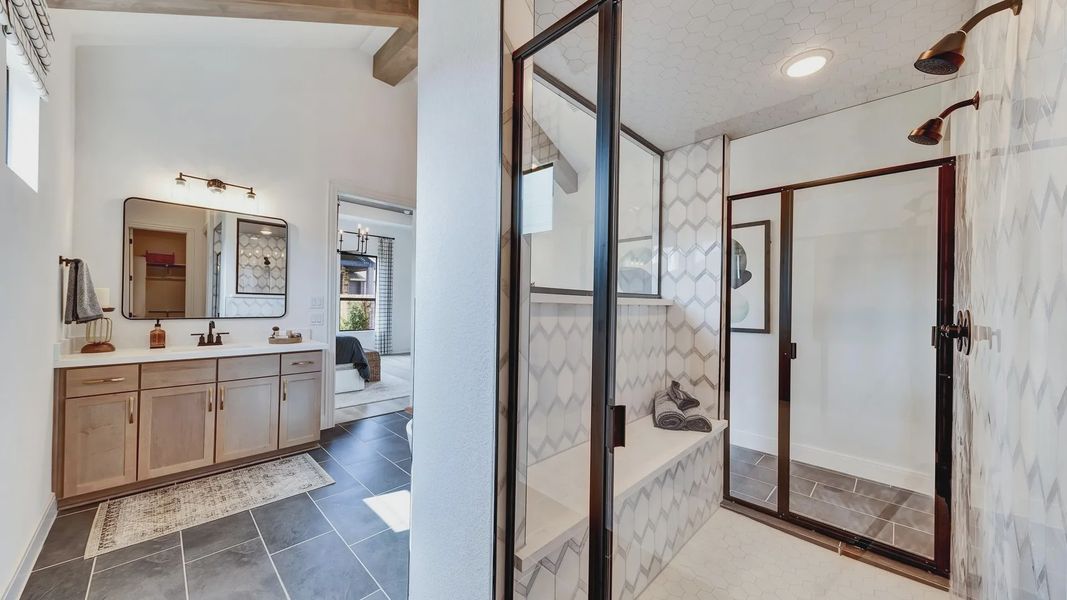 Expansive glass shower and hexagonal tiles accentuate this Hawkes Landing bathroom masterpiece.