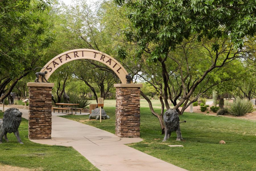 A stone archway with statues in a park.
