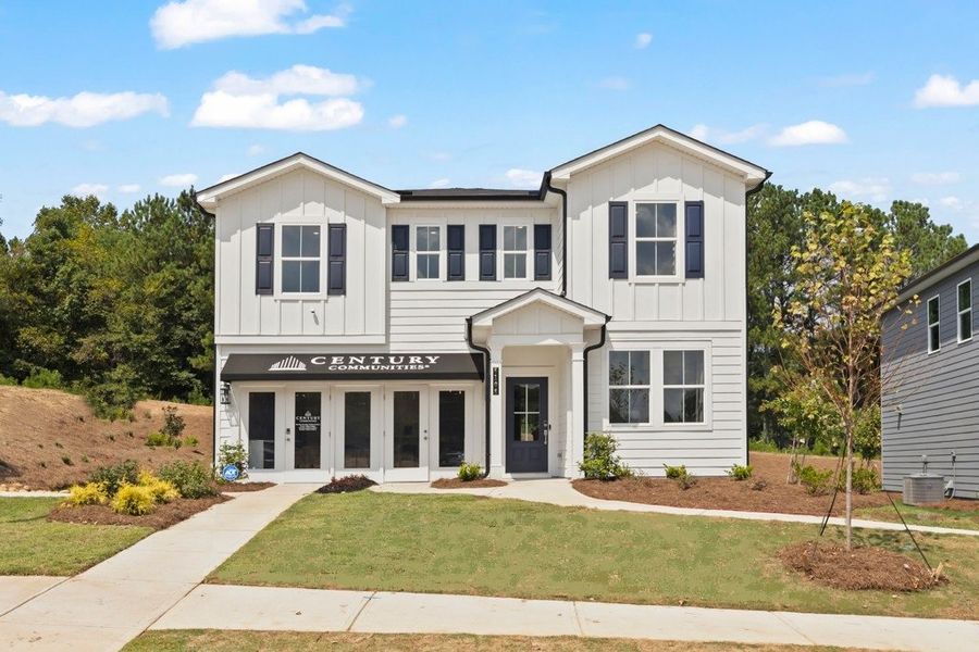 A white building with a lawn in front of it. A white building with a lawn in front of it.
