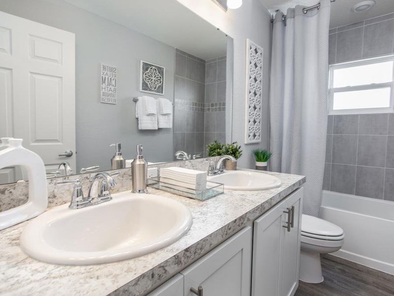 The secondary bedrooms share a large dual vanity hall bath - Serendipity model home in Winter Haven