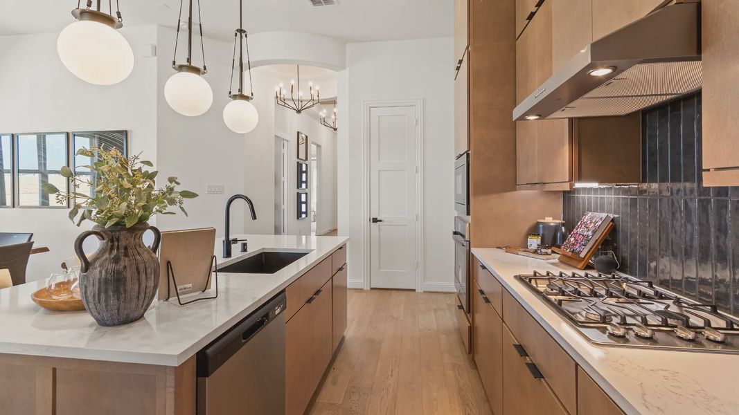 River Ranch home showcases sleek pendant lighting, elegant wood cabinetry, and a chic island.