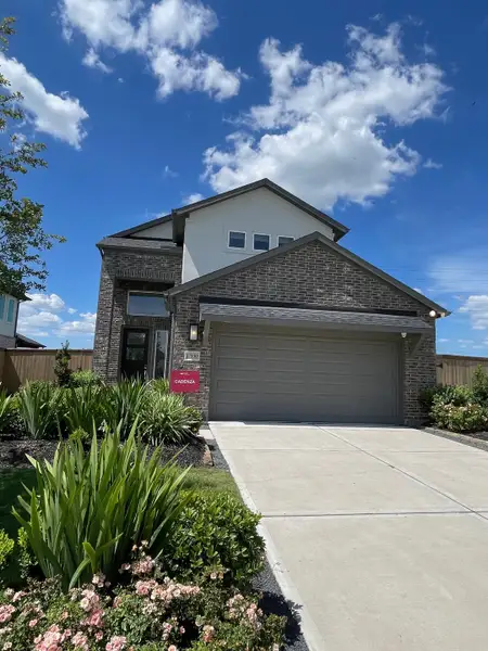 Elegant brick home with a landscaped entrance in Trillium 60s by Taylor Morrison (Richmond, TX).