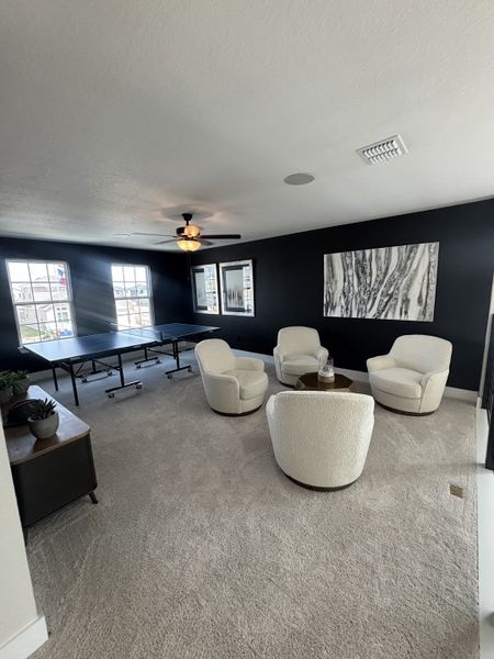 A versatile upstairs loft with a ping-pong table, cozy seating, and large windows providing ample natural light. A versatile upstairs loft with a ping-pong table, cozy seating, and large windows providing ample natural light.