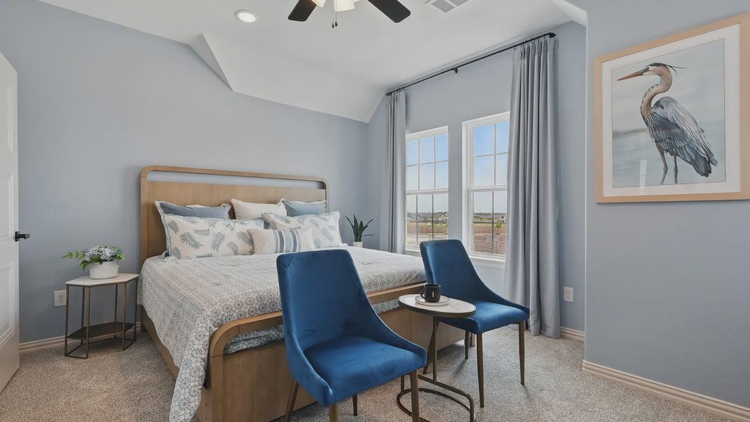Luxurious Westridge bedroom features velvet chairs, a chic wooden bed, and captivating heron artwork.