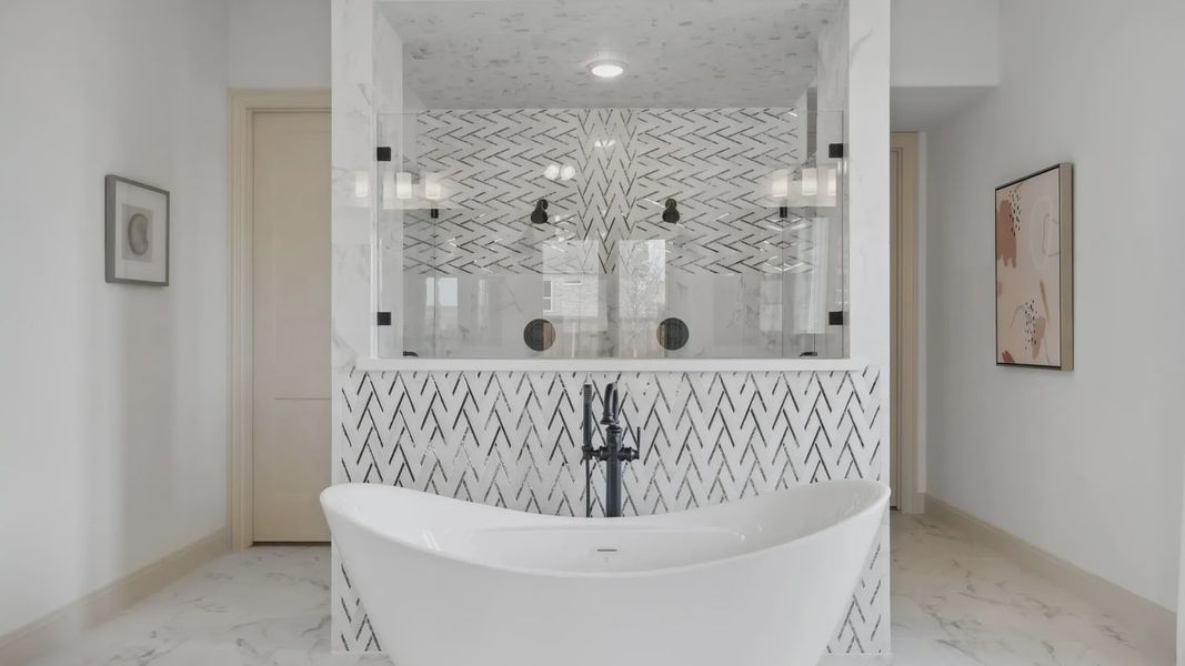 Indulge in opulence with a marble herringbone-tiled shower and elegant freestanding bathtub in Westside Preserve.