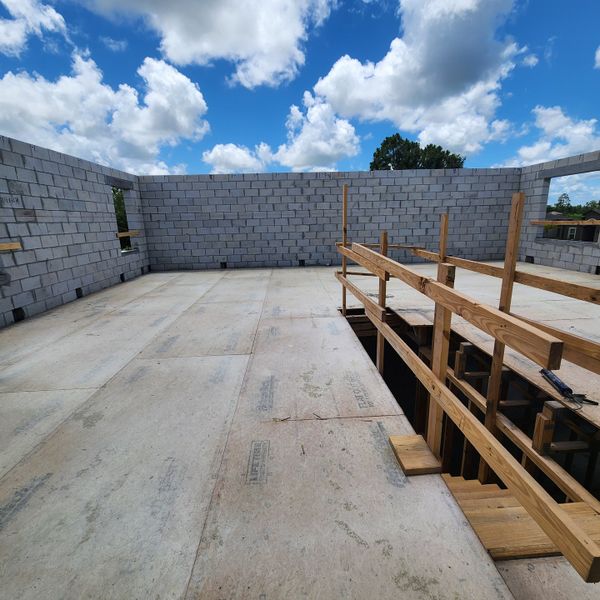 Under-construction home with exposed block walls and open spaces in Palm Bay by D.R. Horton (Palm Bay, FL).