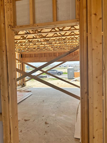 A view of a home under construction with exposed wooden beams and framing.