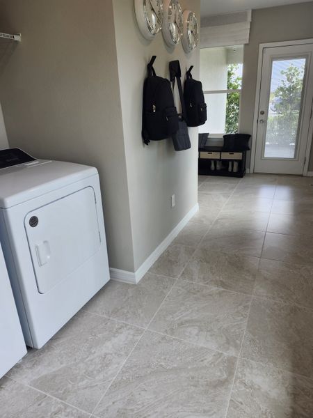A modern laundry room featuring sleek appliances, tiled flooring, and organized storage solutions for a tidy space. A modern laundry room featuring sleek appliances, tiled flooring, and organized storage solutions for a tidy space.