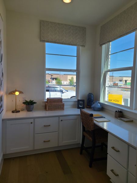 A cozy home office with natural light, built-in desk, wicker chair, and elegant decor elements. A cozy home office with natural light, built-in desk, wicker chair, and elegant decor elements.