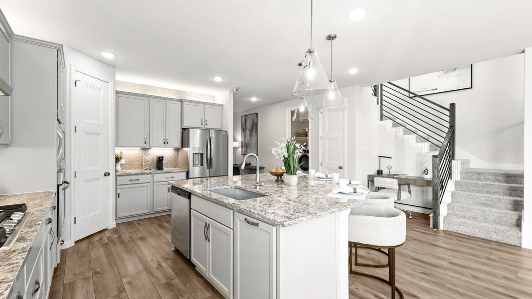 Exquisite marble island and sleek pendant lighting enhance this Green Oaks Preserve kitchen. Exquisite marble island and sleek pendant lighting enhance this Green Oaks Preserve kitchen.