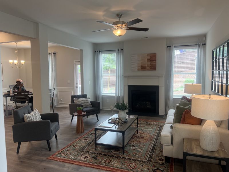 A cozy living room with a fireplace, neutral tones, modern furniture, and ample natural light from large windows. A cozy living room with a fireplace, neutral tones, modern furniture, and ample natural light from large windows.