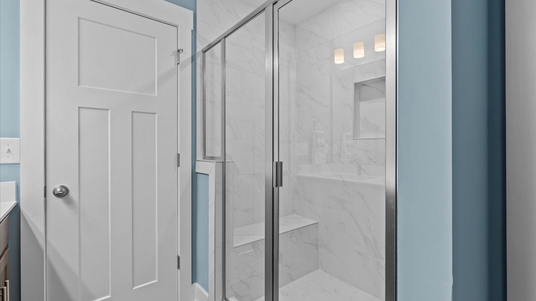 Luxe tiled walk-in shower with bench seat in two story townhome at Ransdell Pointe by DRB Homes in Spartanburg, SC