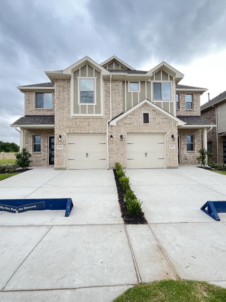 A modern duplex with brick and trim in Elevon by Pacesetter Homes, featuring double garages and neat landscaping (Lavon, TX).