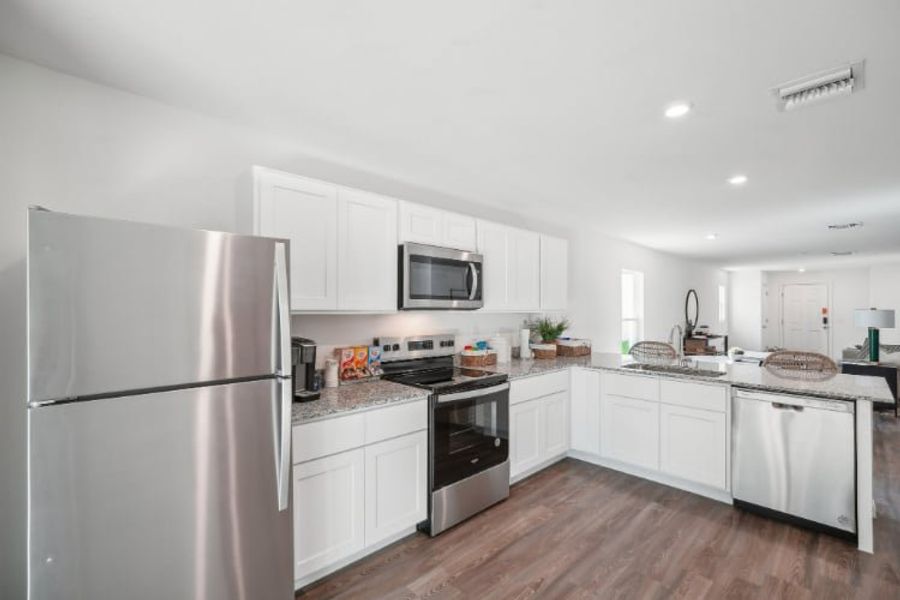 A kitchen with white cabinets.