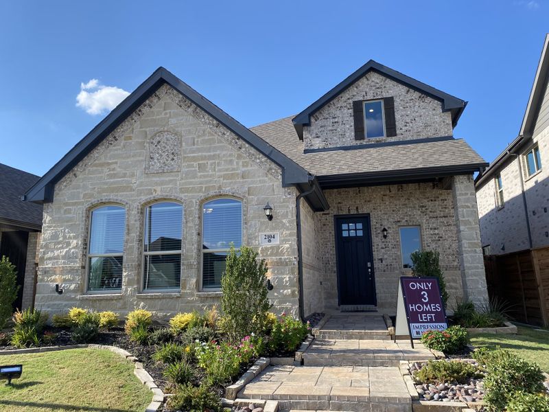 Charming stone and brick home with lush landscaping in Solterra by Impression Homes (Mesquite, TX).