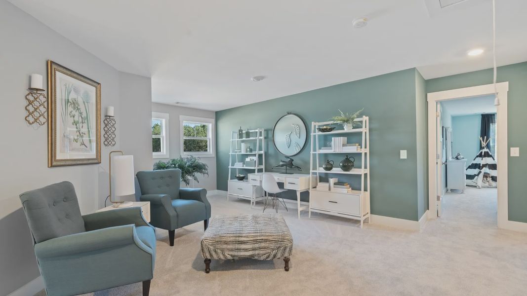 Botanical themed loft space with green accent wall and cozy carpeted flooring at Village at Midway by DRB Homes Botanical themed loft space with green accent wall and cozy carpeted flooring at Village at Midway by DRB Homes