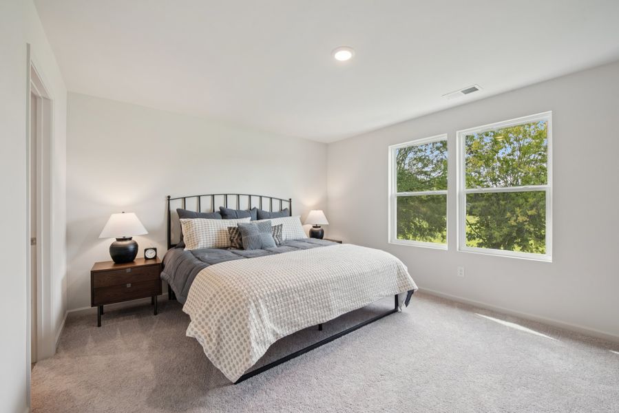 A bedroom with a bed and a window.