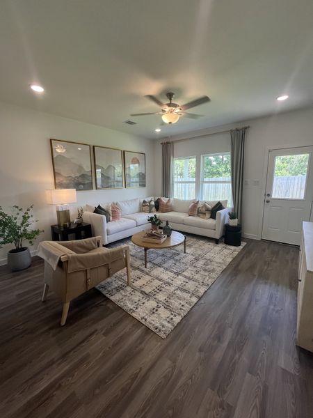 A cozy living room with a spacious white sectional, chic decor, and large windows offering natural light.