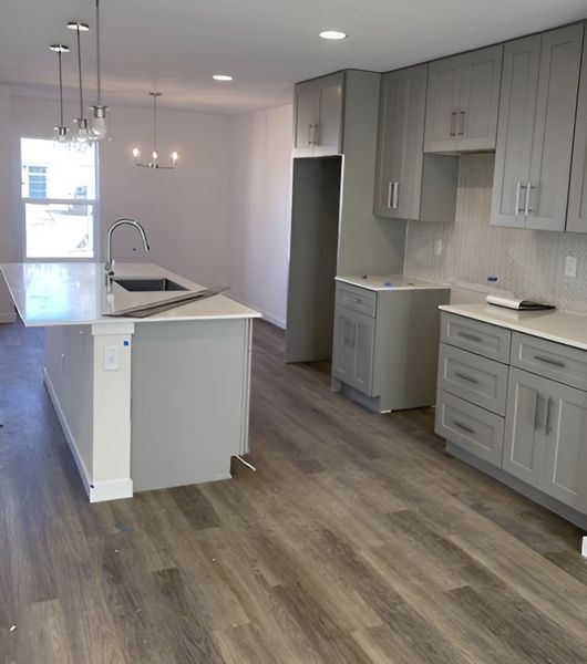 A second view of the spacious kitchen showcasing open-concept design, ample storage, and a stylish backsplash.