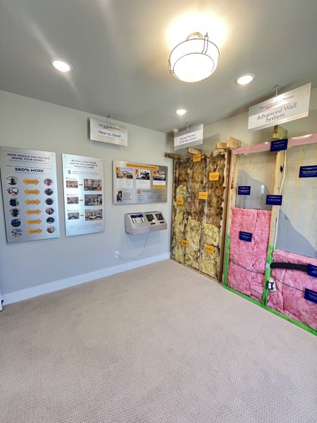 A modern showroom displaying advanced wall systems and informational displays on construction techniques. A modern showroom displaying advanced wall systems and informational displays on construction techniques.