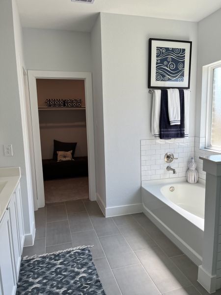 A modern bathroom featuring a sleek tub, stylish gray tiles, and elegant decor for a tranquil retreat.