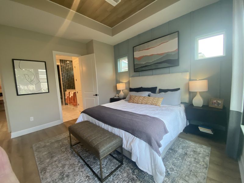 A cozy bedroom with a stylish gray accent wall, warm lighting, and modern decor.