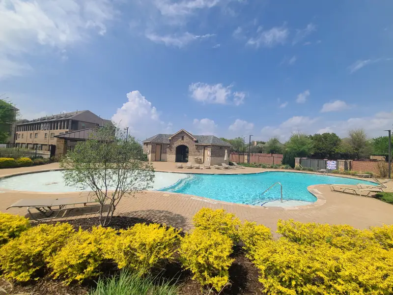 A luxurious pool and clubhouse area with landscaped grounds in Wade Settlement by Megatel Homes (Frisco, TX).
