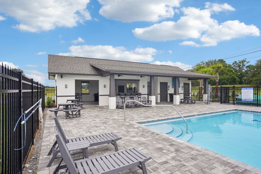 A swimming pool in front of a house.