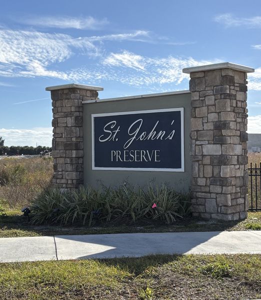 Elegant entrance sign for St. Johns Preserve by Landsea Homes in Palm Bay, FL, featuring stone pillars and lush landscaping.