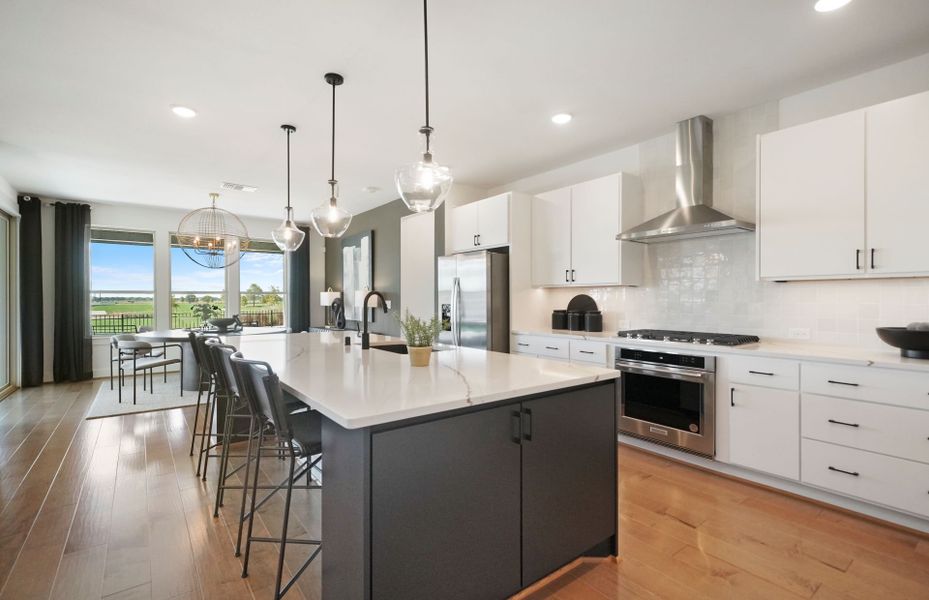 Oversized kitchen island with bar-top seating in floor plan at Del Webb Fulshear 55+ community