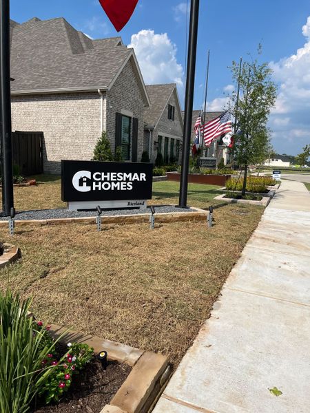 Charming brick home with manicured lawn in Riceland by Chesmar Homes, Mont Belvieu, TX.