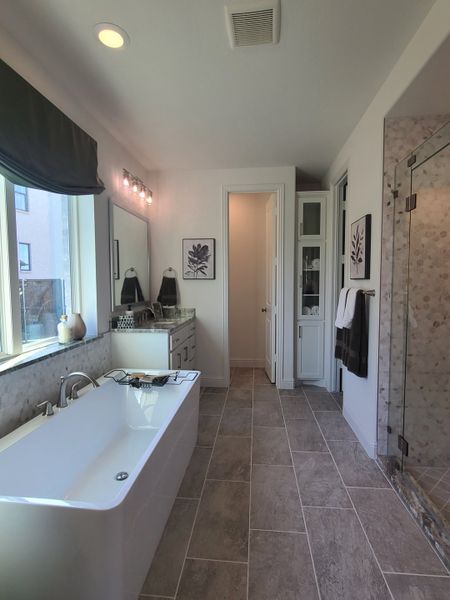 A sleek bathroom featuring a freestanding tub, dual vanity, and a glass-enclosed shower with elegant decor.