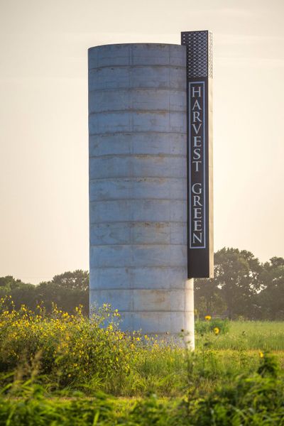 Entrance to the Harvest Green 65' community in Richmond, TX, featuring signage and landscaping (Image 1). Entrance to the Harvest Green 65' community in Richmond, TX, featuring signage and landscaping (Image 1).