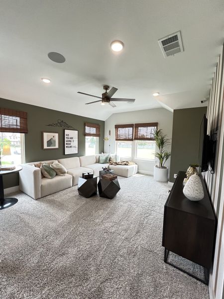 A modern living room with a cozy L-shaped sofa, geometric tables, and large windows providing plenty of natural light.