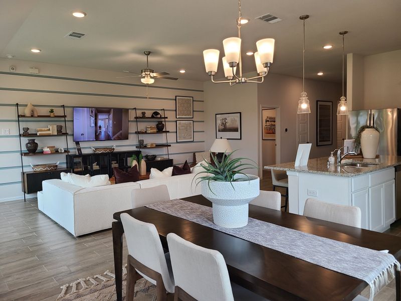 A modern open-concept living area with sleek furnishings, a stylish dining table, and a cozy kitchen island. A modern open-concept living area with sleek furnishings, a stylish dining table, and a cozy kitchen island.