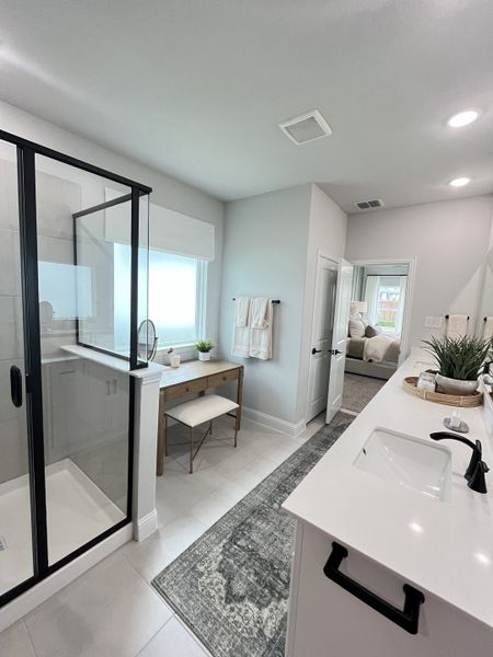 A modern bathroom featuring a spacious shower, sleek vanity, and elegant decor with natural light.