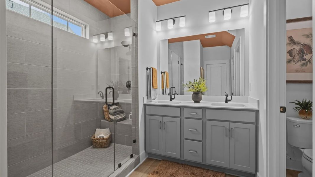 Ranch style home with stunning primary bathroom with frameless walk-in tiled shower, double sink vanity, and modern finishes