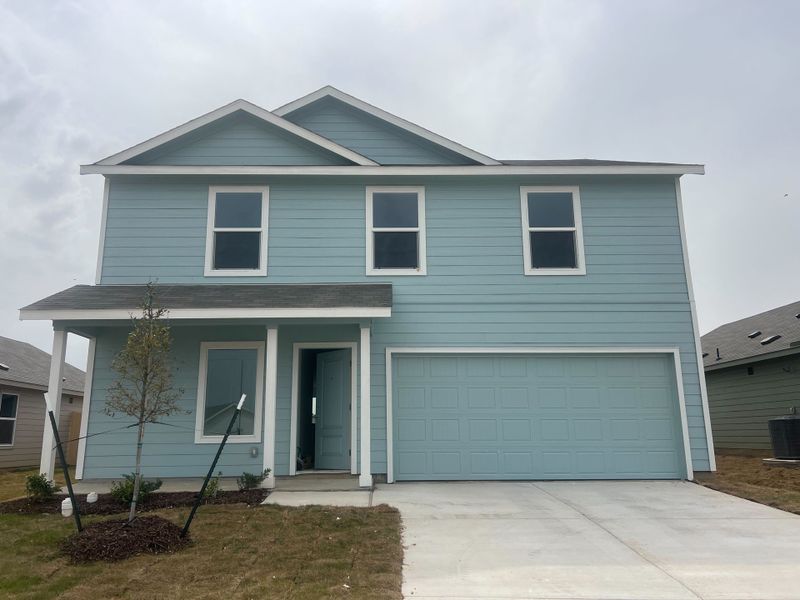 A charming blue home with modern design and a two-car garage in Shale Creek: Cottage Collection by Lennar (Justin, TX).