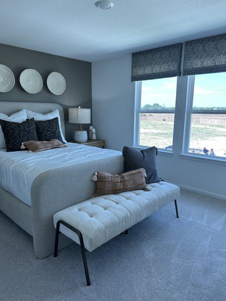 Inviting bedroom with a sleek upholstered bed, cozy bench, and natural light pouring through large windows. Inviting bedroom with a sleek upholstered bed, cozy bench, and natural light pouring through large windows.