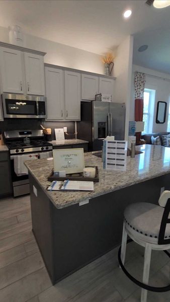 A modern kitchen featuring granite countertops, sleek cabinetry, and stainless steel appliances.