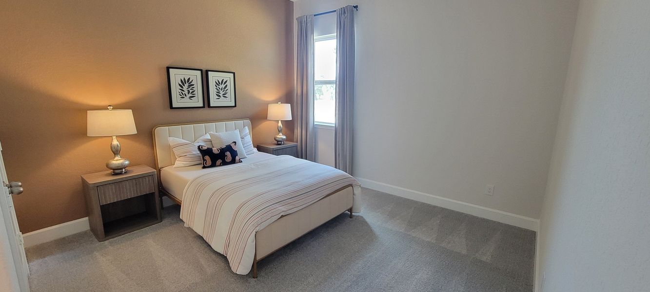 A cozy bedroom featuring a plush bed, modern nightstands, and soft lighting. Neutral tones create a serene atmosphere.